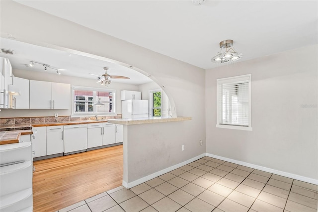 kitchen featuring white cabinets, white appliances, kitchen peninsula, and light hardwood / wood-style flooring