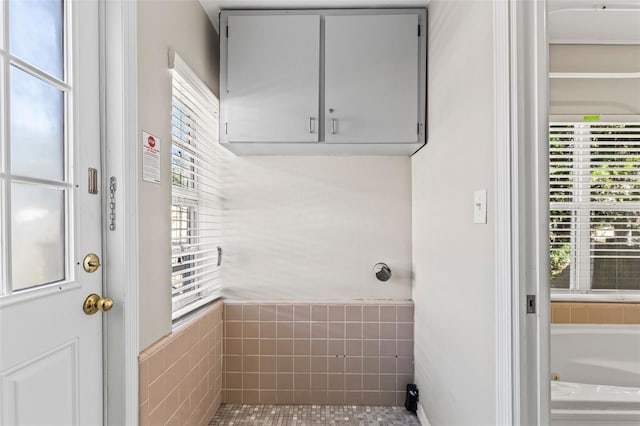 interior space featuring tile patterned floors, a wealth of natural light, and tile walls