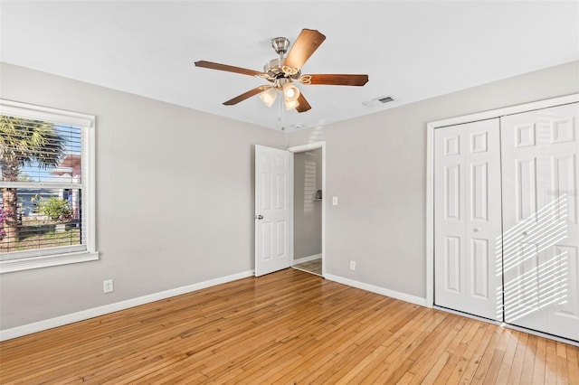 unfurnished bedroom with a closet, light hardwood / wood-style flooring, and ceiling fan