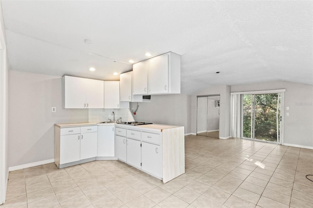 kitchen with white cabinets, lofted ceiling, sink, and stainless steel gas cooktop