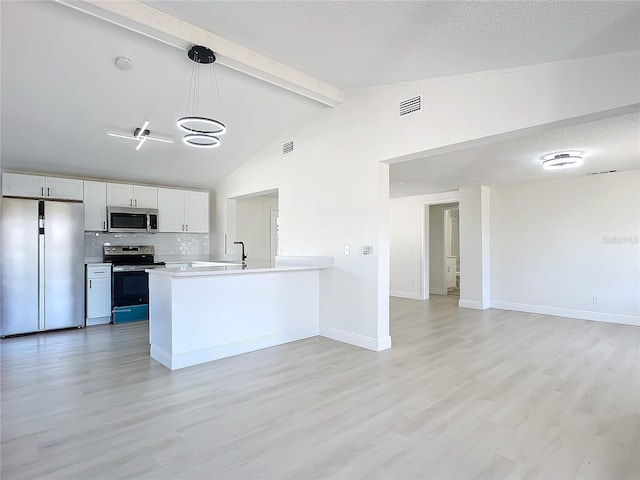 kitchen with vaulted ceiling with beams, light wood-type flooring, appliances with stainless steel finishes, decorative light fixtures, and kitchen peninsula