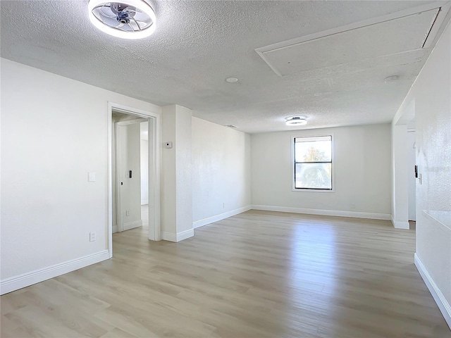 empty room featuring ceiling fan, light hardwood / wood-style floors, and a textured ceiling