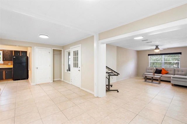 unfurnished living room with light tile patterned floors and ceiling fan