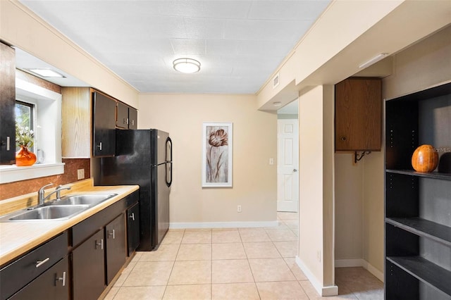 kitchen with decorative backsplash, light tile patterned flooring, dark brown cabinetry, and sink