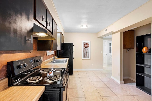 kitchen featuring black range with electric stovetop, sink, light tile patterned flooring, and dark brown cabinets