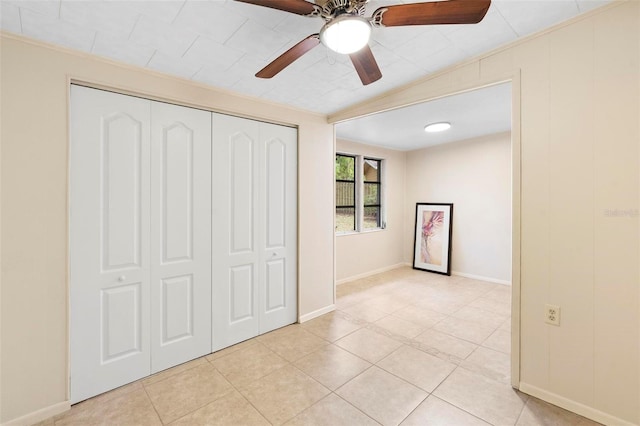 unfurnished bedroom with ceiling fan, light tile patterned flooring, and a closet