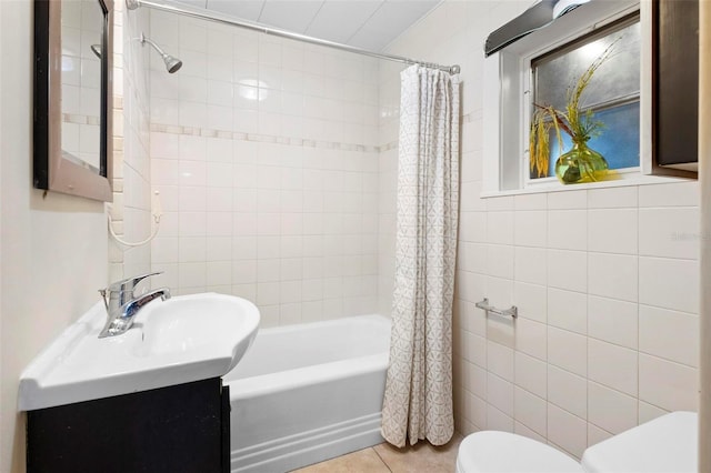 full bathroom featuring shower / bathtub combination with curtain, tile patterned floors, toilet, vanity, and tile walls