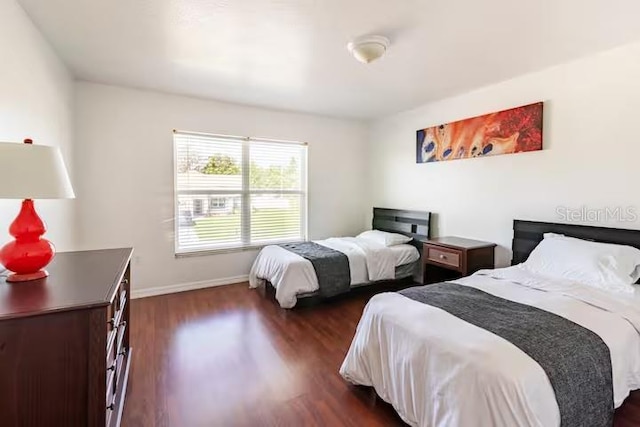 bedroom with dark hardwood / wood-style flooring