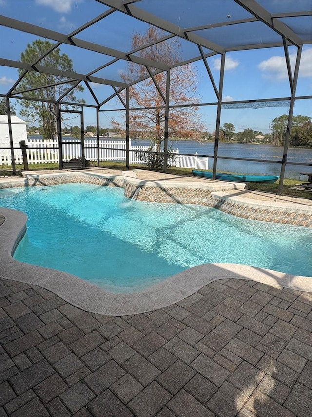 view of pool featuring a lanai, a patio area, a water view, and pool water feature