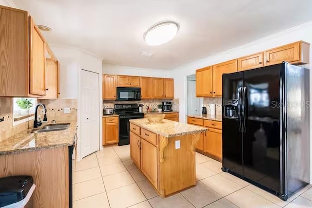 kitchen featuring black appliances, a kitchen island, light stone countertops, and sink