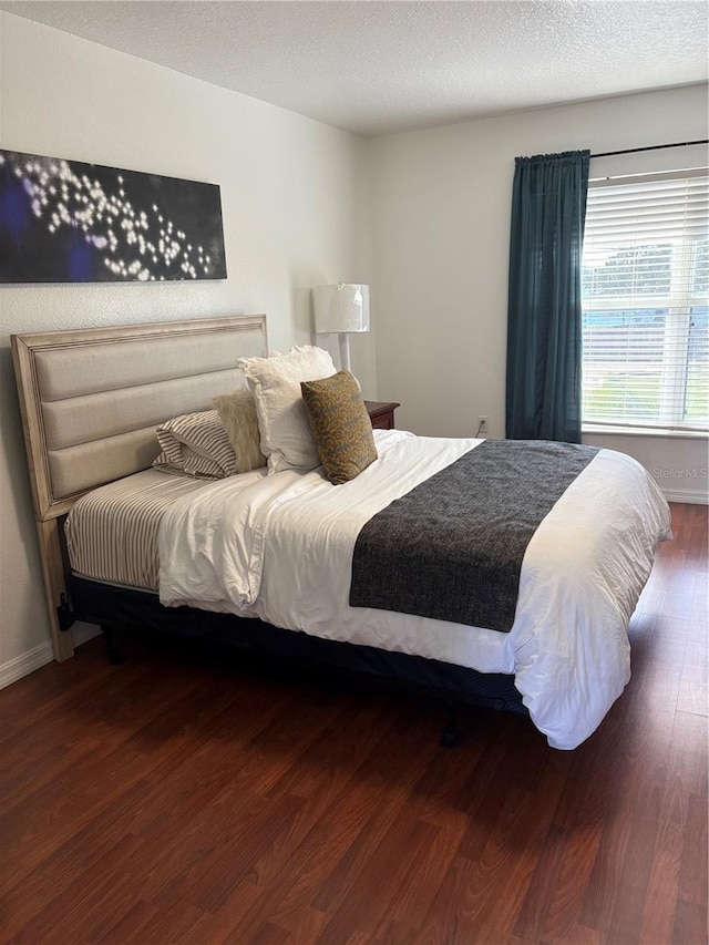 bedroom featuring a textured ceiling and dark wood-type flooring