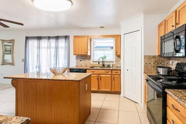 kitchen with black appliances, decorative backsplash, a kitchen island, and sink