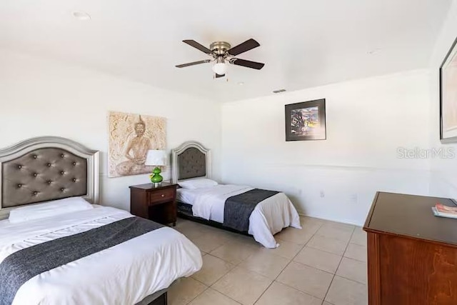 bedroom with ceiling fan and light tile patterned floors