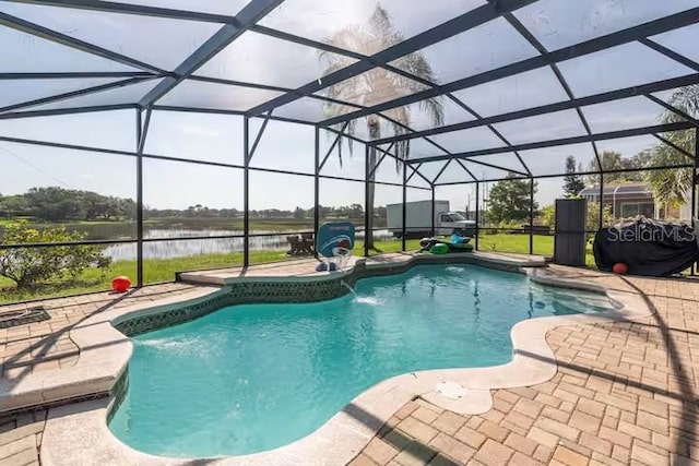 view of pool featuring pool water feature, a patio, a water view, and glass enclosure