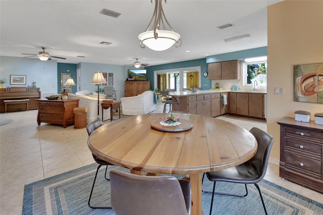 dining room featuring sink, ceiling fan, and light tile patterned flooring