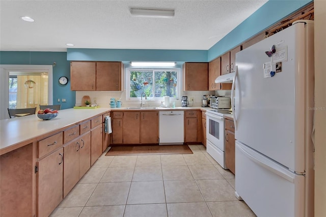 kitchen featuring white appliances, backsplash, sink, light tile patterned floors, and a textured ceiling