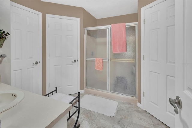 bathroom featuring an enclosed shower and sink