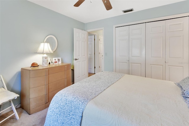 carpeted bedroom featuring ceiling fan and a closet