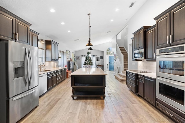 kitchen with pendant lighting, a center island, stainless steel appliances, and tasteful backsplash