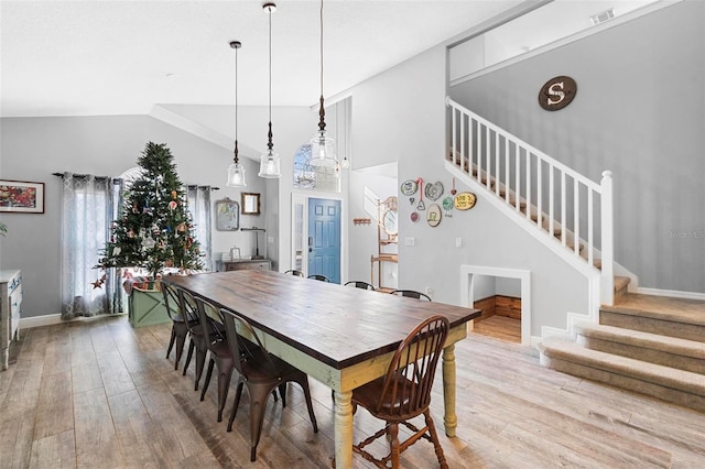 dining space with light hardwood / wood-style flooring and lofted ceiling