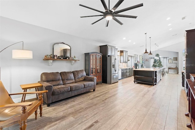 living room with light wood-type flooring, vaulted ceiling, and ceiling fan