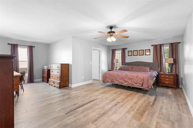 bedroom with a textured ceiling, light wood-type flooring, and ceiling fan