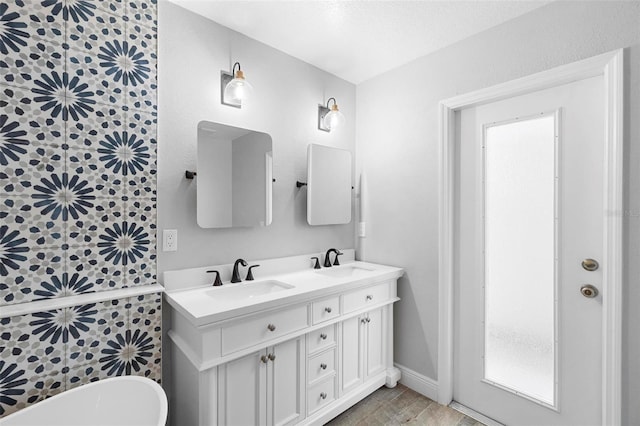 bathroom with hardwood / wood-style floors, vanity, and a bathtub