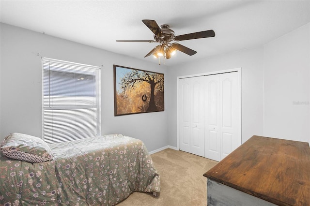 carpeted bedroom featuring ceiling fan and a closet