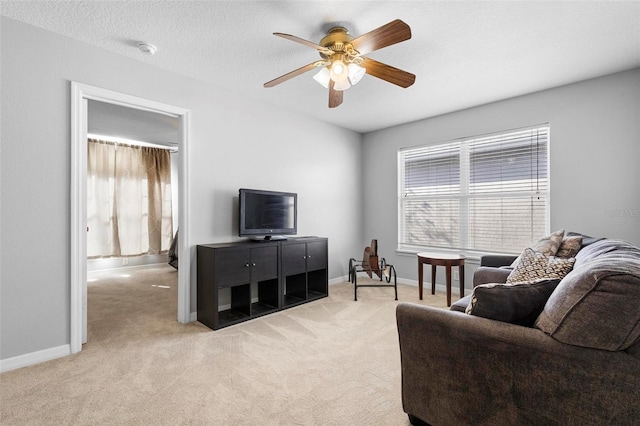 carpeted living room featuring ceiling fan and a textured ceiling