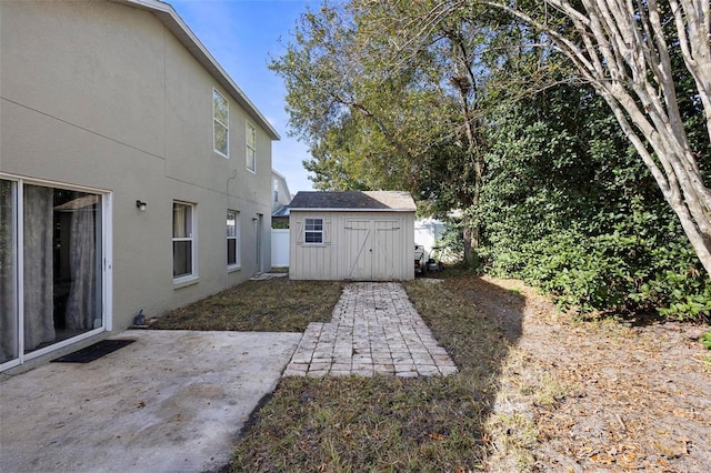 view of yard featuring a patio and a storage shed