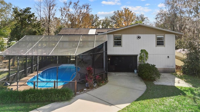 back of property featuring glass enclosure and a garage