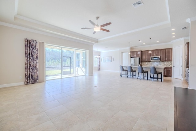 living room featuring ceiling fan, a raised ceiling, light tile patterned floors, and crown molding