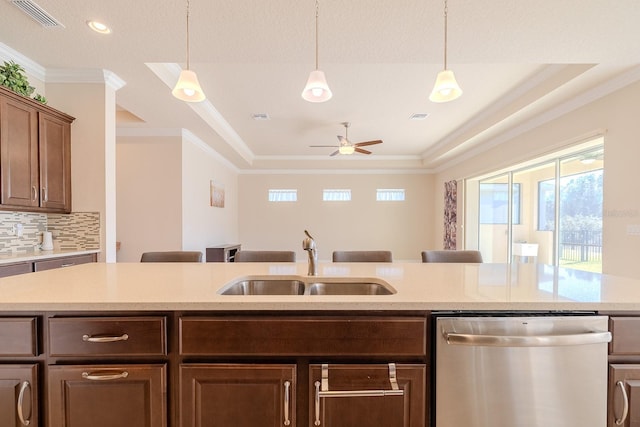 kitchen with a kitchen bar, ornamental molding, sink, dishwasher, and hanging light fixtures