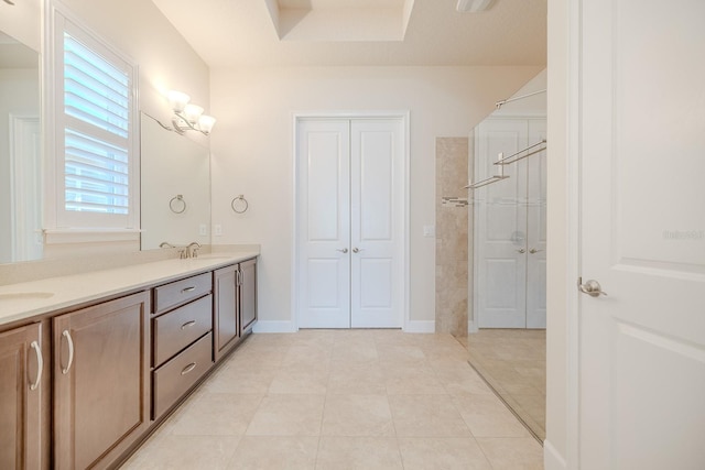 bathroom featuring tile patterned flooring, a shower, and vanity