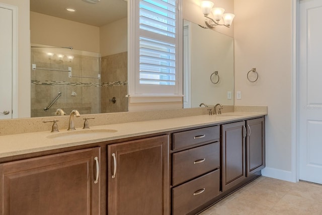 bathroom with tile patterned floors, vanity, tiled shower, and an inviting chandelier