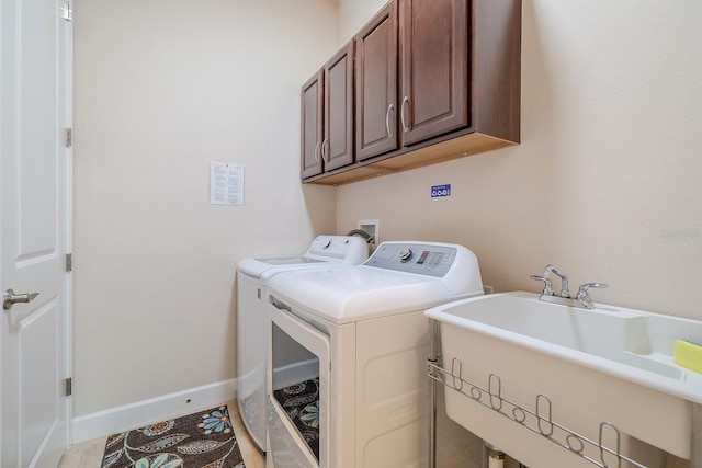 clothes washing area featuring cabinets, washing machine and dryer, light tile patterned floors, and sink