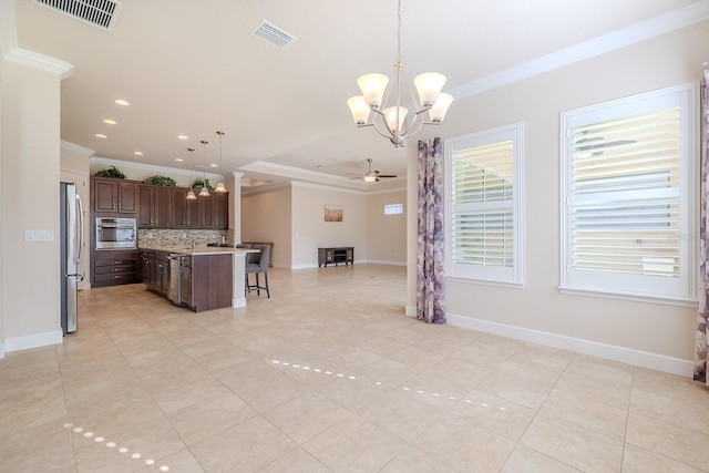 kitchen featuring stainless steel fridge, ornamental molding, ceiling fan with notable chandelier, decorative light fixtures, and a center island