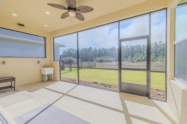 unfurnished sunroom with a wealth of natural light and ceiling fan