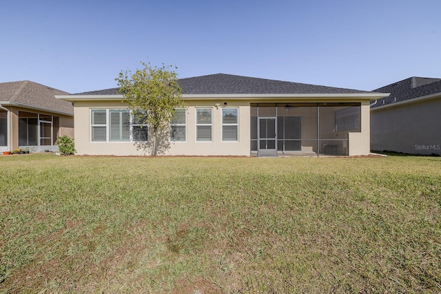 back of house with a lawn and a sunroom