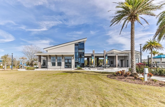 rear view of property with a lawn and a patio