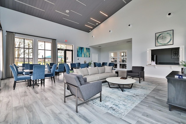 living room with light hardwood / wood-style flooring, high vaulted ceiling, and french doors