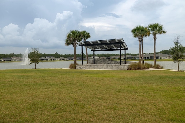 surrounding community with a water view and a lawn