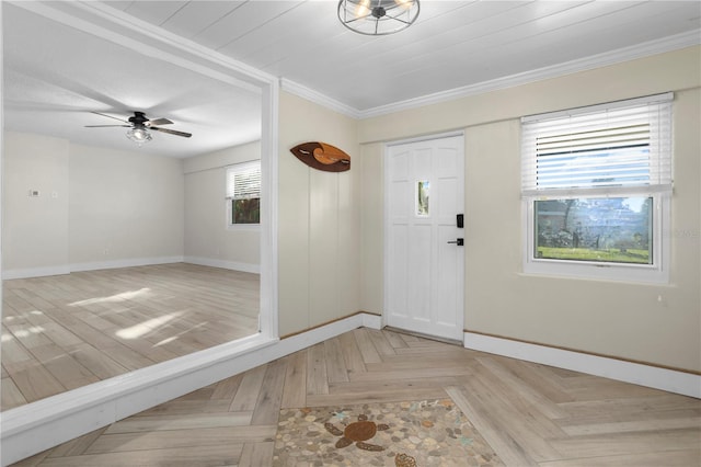 foyer entrance with ceiling fan, crown molding, and light parquet floors