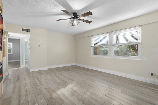 unfurnished room with ceiling fan, a textured ceiling, and light hardwood / wood-style flooring