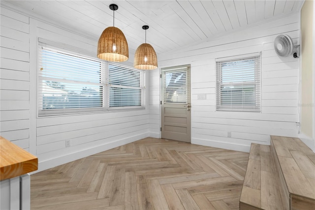 unfurnished dining area with wooden walls, light parquet floors, wooden ceiling, and lofted ceiling