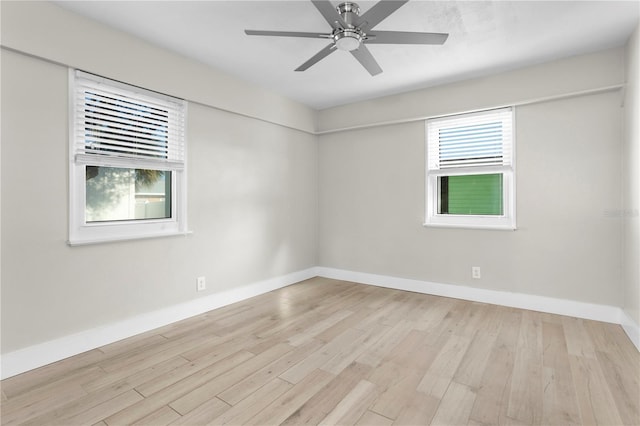 spare room featuring light hardwood / wood-style floors, a wealth of natural light, and ceiling fan