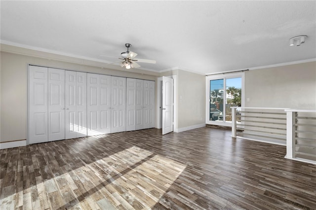 interior space with ornamental molding, a textured ceiling, ceiling fan, and dark wood-type flooring