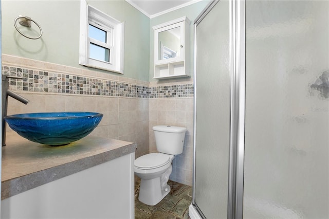 bathroom featuring vanity, toilet, a shower with door, and tile walls