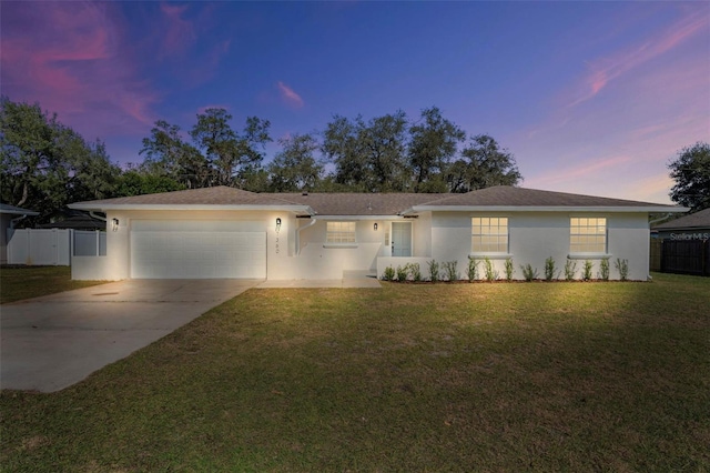 ranch-style house with a yard and a garage