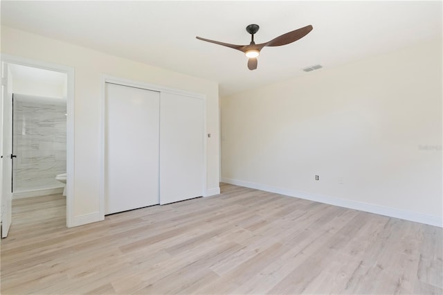 unfurnished bedroom featuring light wood-type flooring, connected bathroom, a closet, and ceiling fan